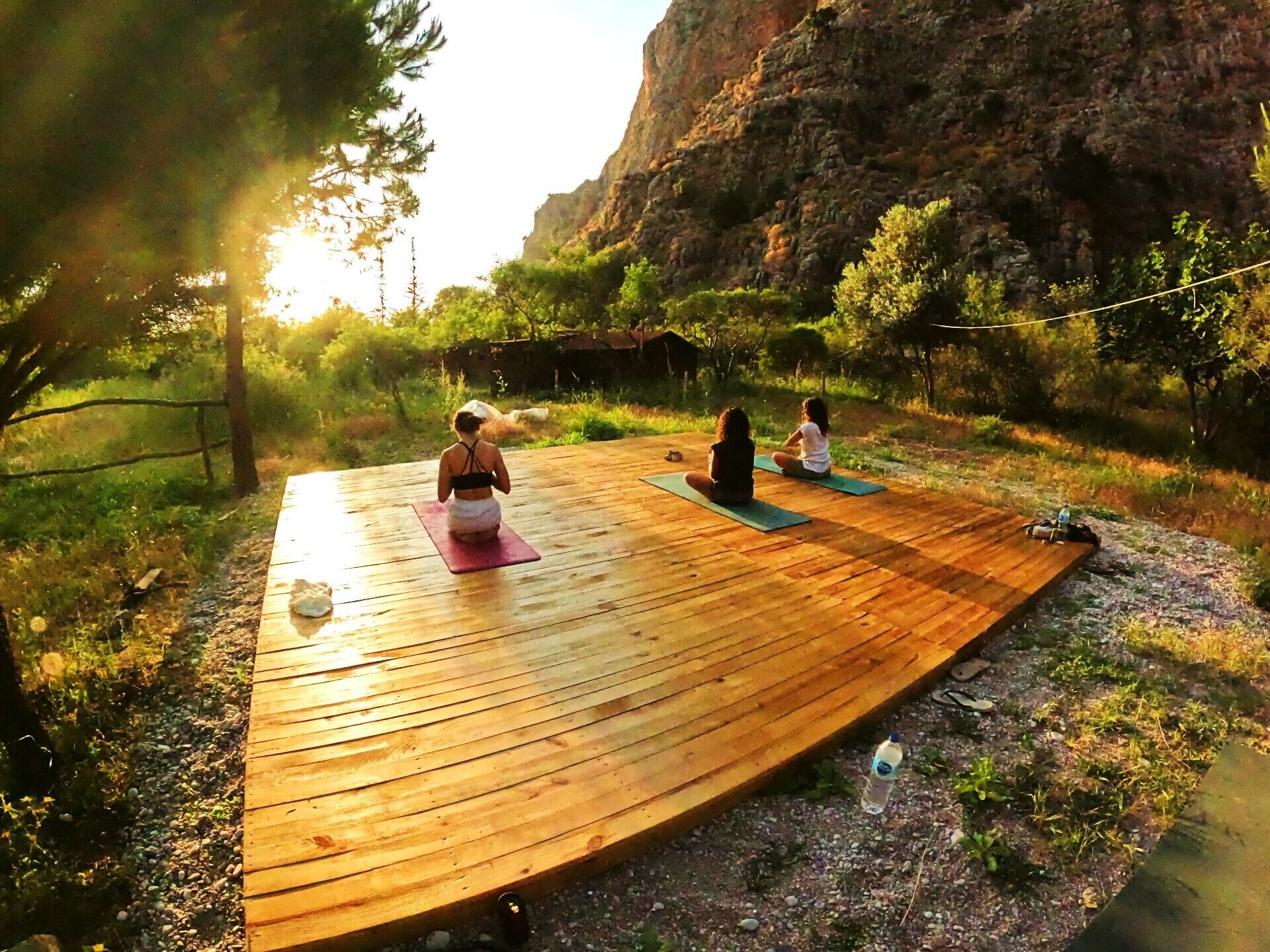 En træterrasse med to personer der dyrker yoga.