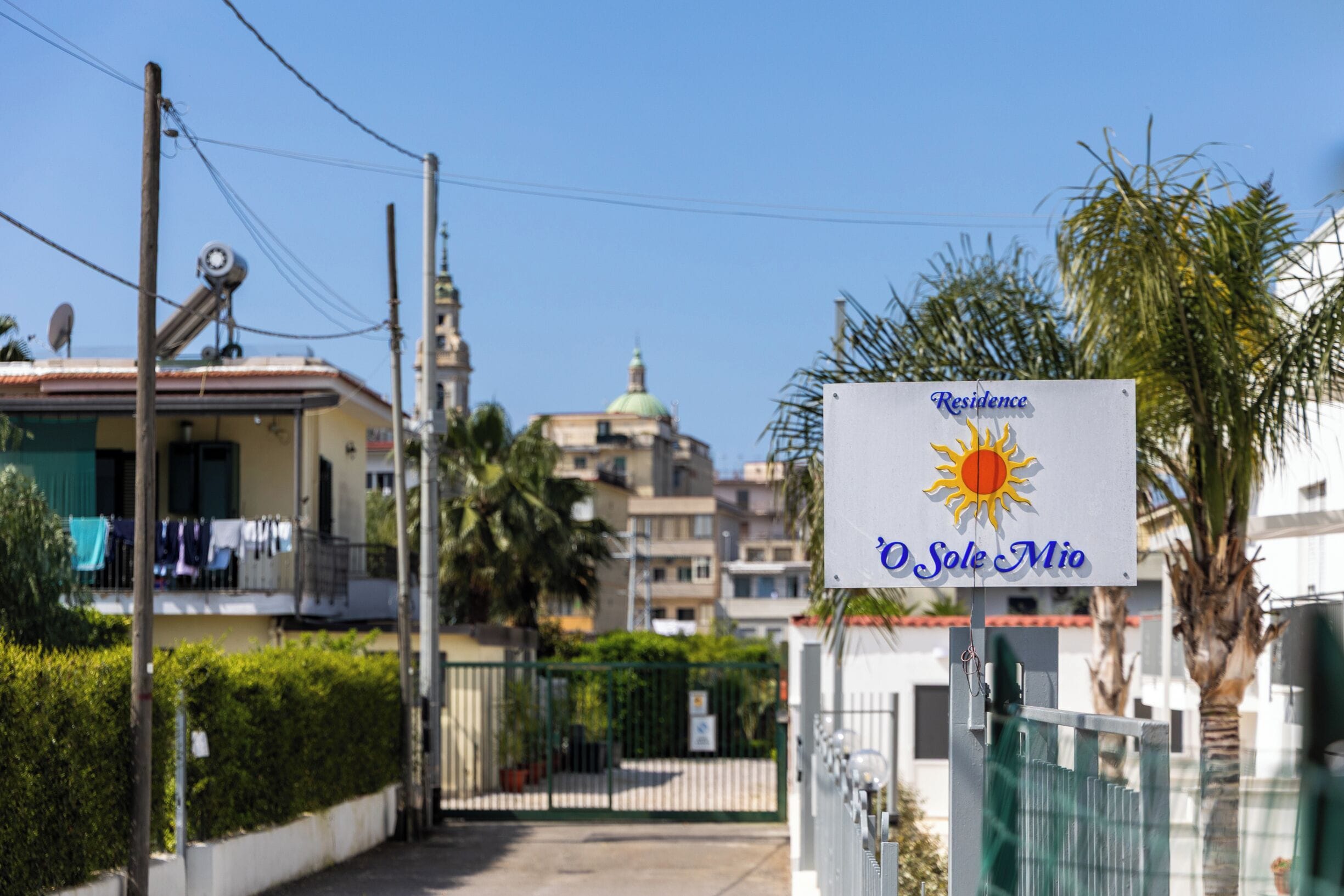 A residential area with a sign for 'Residence O Sole Mio' and a gated entrance.