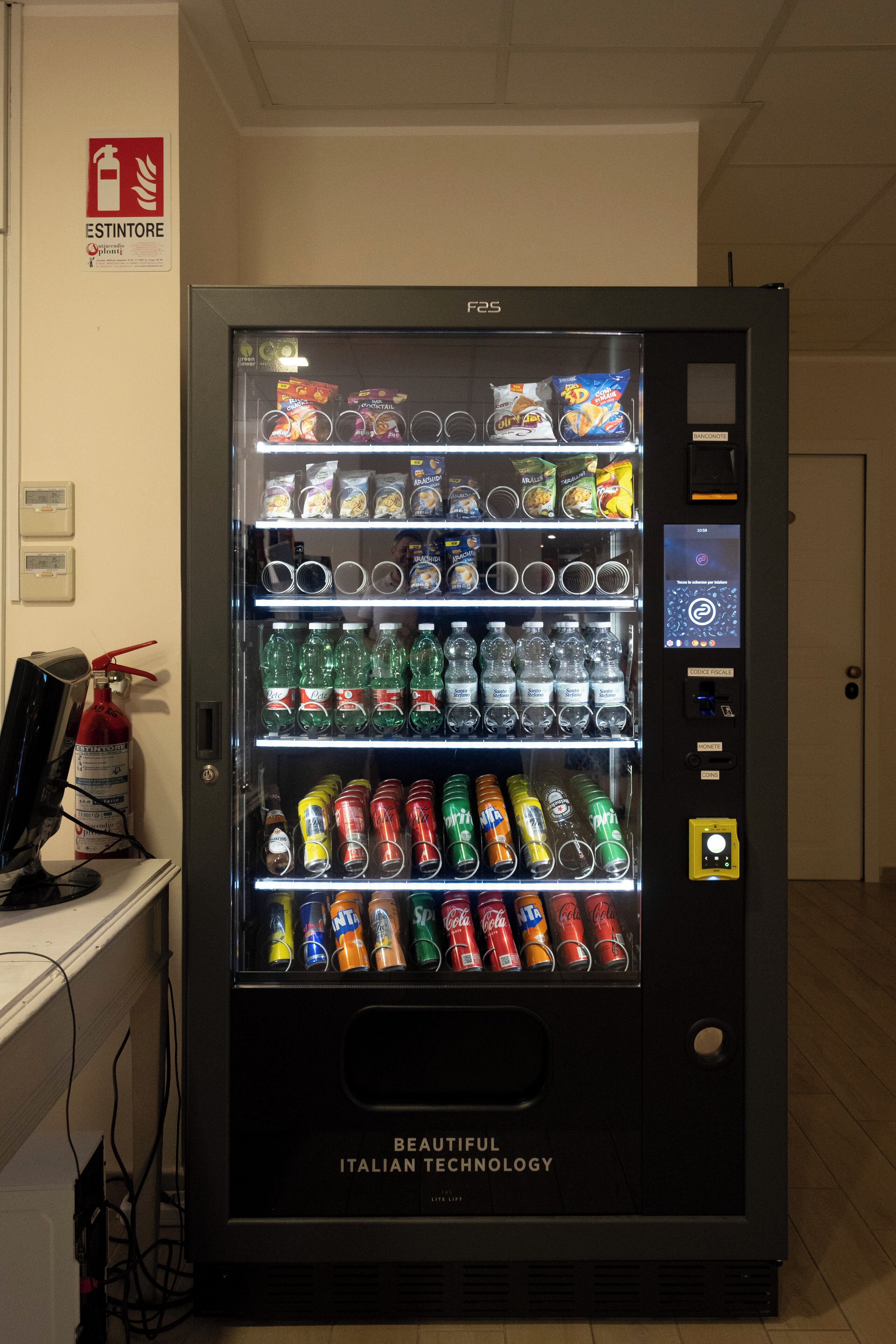 A vending machine with various snacks, drinks, and glasses.
