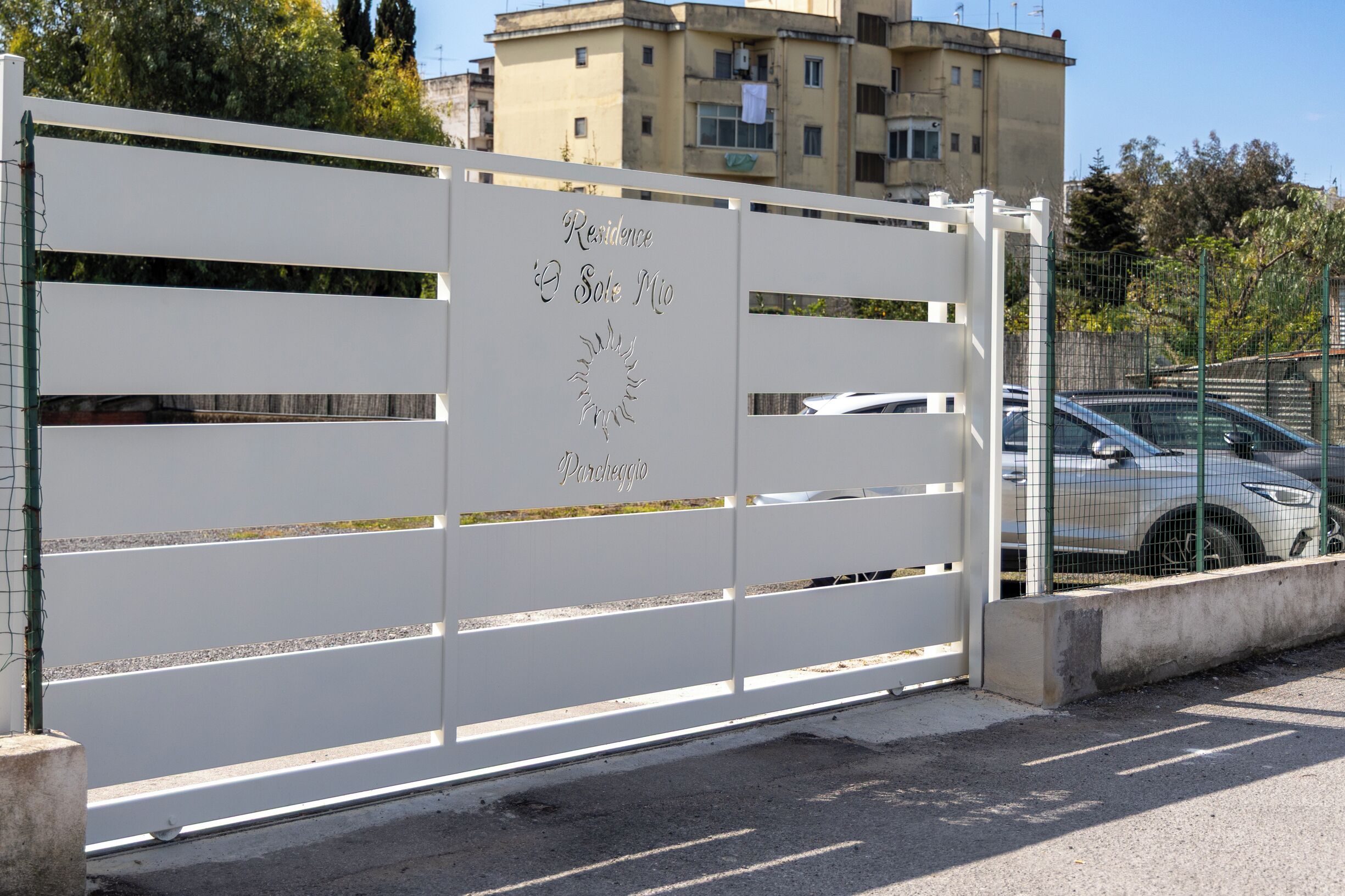 A white metal gate with the words "Residence Sole Mio" and "Pardeggio" engraved on it.