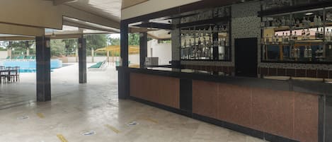 A covered outdoor area with a bar and seating.