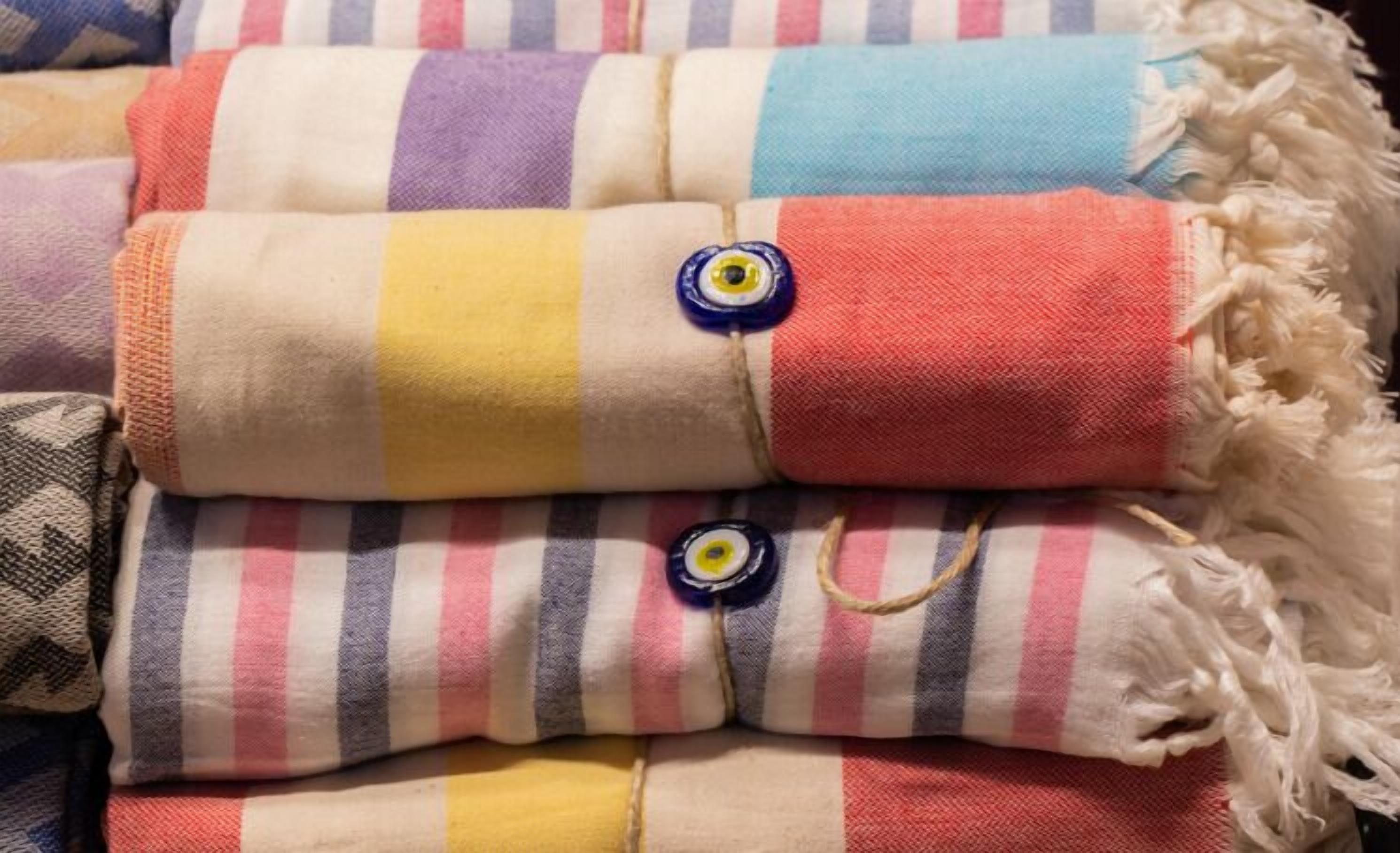 A stack of folded blankets with various patterns and colors.