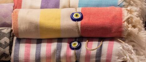 A stack of folded blankets with various patterns and colors.
