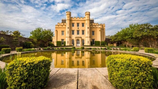 A castle-like building with a symmetrical facade, a central entrance, and a surrounding moat with water. - Livestay - One Bed Apt, Free Parking, Sleeps 4 (Slough)