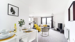 A modern living room with a dining area, a sofa set, and a TV. - Livestay - One Bed Apt, Free Parking, Sleeps 4 (Slough)