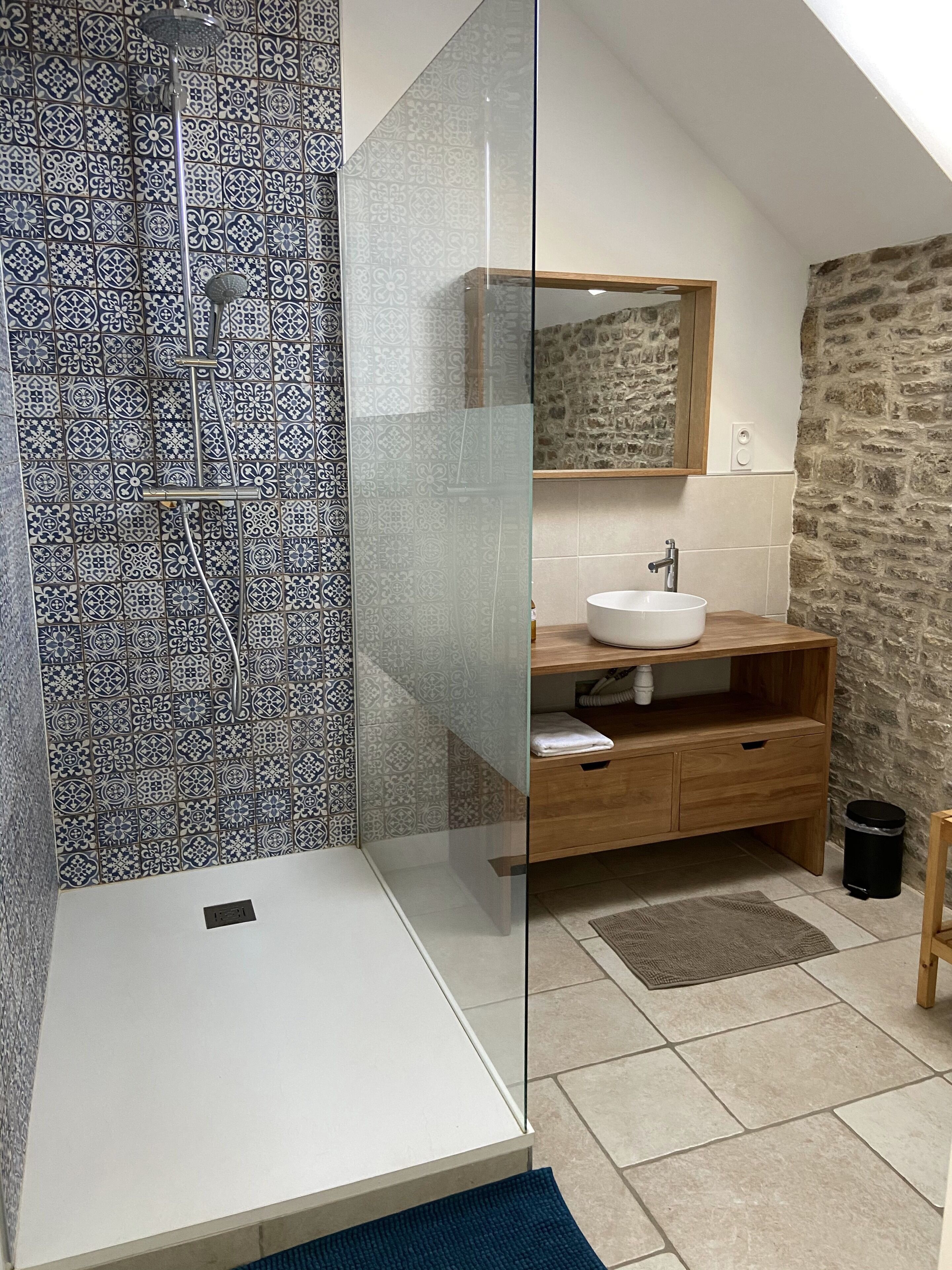 Une salle de bain avec une douche, un lavabo et un miroir.
