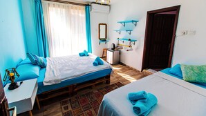 A bedroom with two beds, a desk, a mirror, and a wardrobe. - Tuthaliya Hotel (Kas)