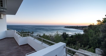 Un balcón con vista al mar y a la costa rocosa.