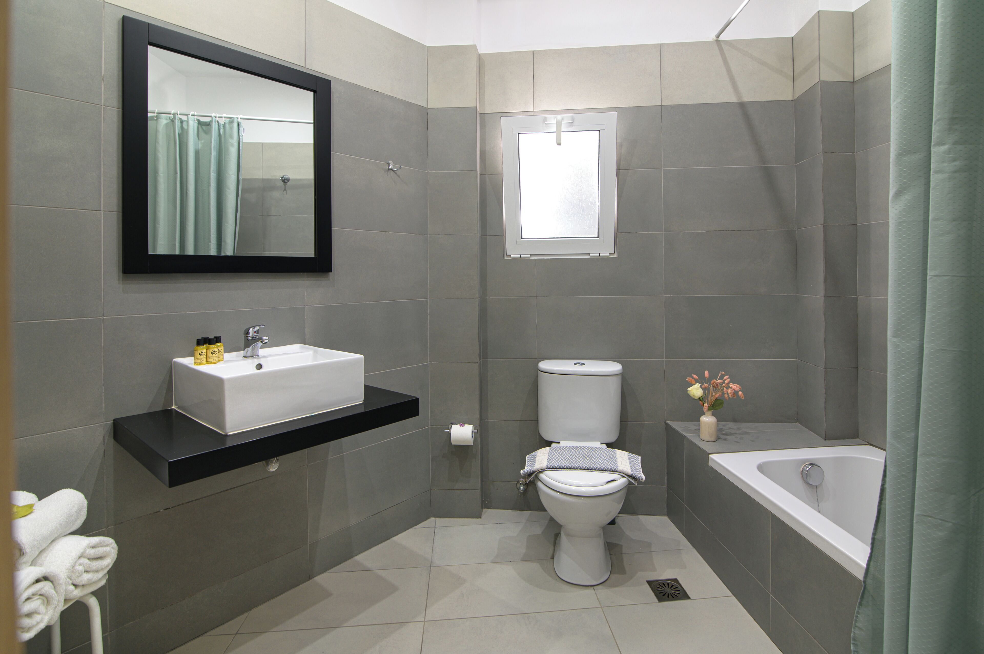 A modern bathroom with a white sink, toilet, and bathtub.