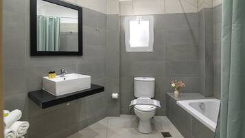 A modern bathroom with a white sink, toilet, and bathtub.