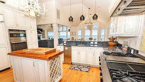 A modern kitchen with white cabinetry, stainless steel appliances, and a central island. - OCEANFRONT, Ocean views, ELEV, Private Pool, Private beach access, WL1083, Lighthouse Drive (Corolla)