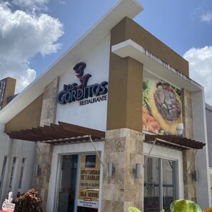 Un restaurant anomenat 'Los Gorditos Restaurante' amb un cartell gran i una pissarra anunciant oportunitats de treball.