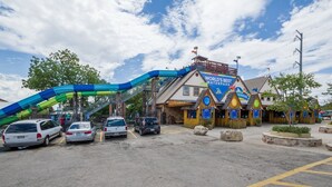 Ein Parkplatz mit Autos, einer Wasserrutsche und einem Gebäude mit der Aufschrift 'WORLD'S BEST WATERPARK'.