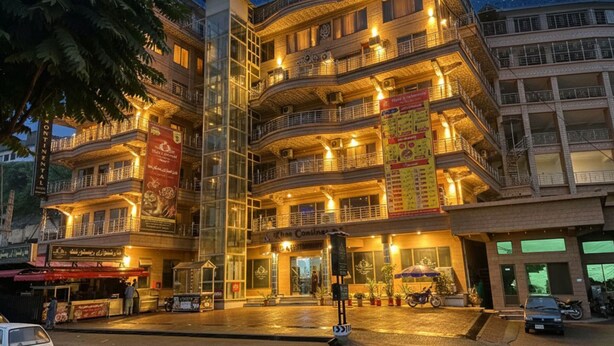 A multi-story hotel with balconies, a covered entrance, and a signboard advertising a restaurant. - Khan Continental Hotel & Restaurant (Mansehra)