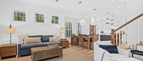 A spacious living room with a sofa, coffee table, and dining area.