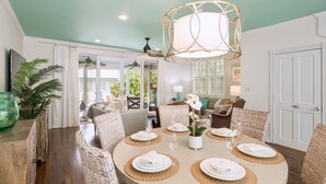 A dining area with a round table set for six, surrounded by wicker chairs. - **ISLAND INSPIRATION @ OLD TOWN** Home & Pool + Last Key White Glove Service... (Key West)