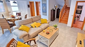 A modern living room with a sofa, coffee table, and dining area. - Casa Balimar - Pool, Jacuzzi, Internet, Garten, Meerblick (Tarajalejo)