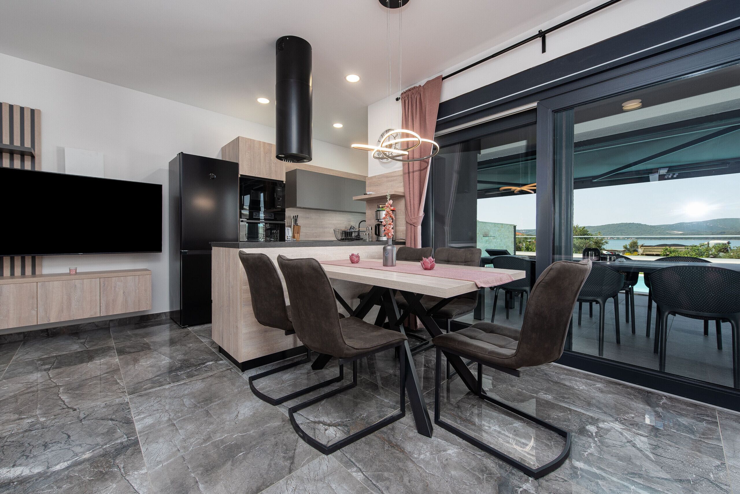 Una cocina moderna con comedor, ventanas amplias y vistas al exterior.