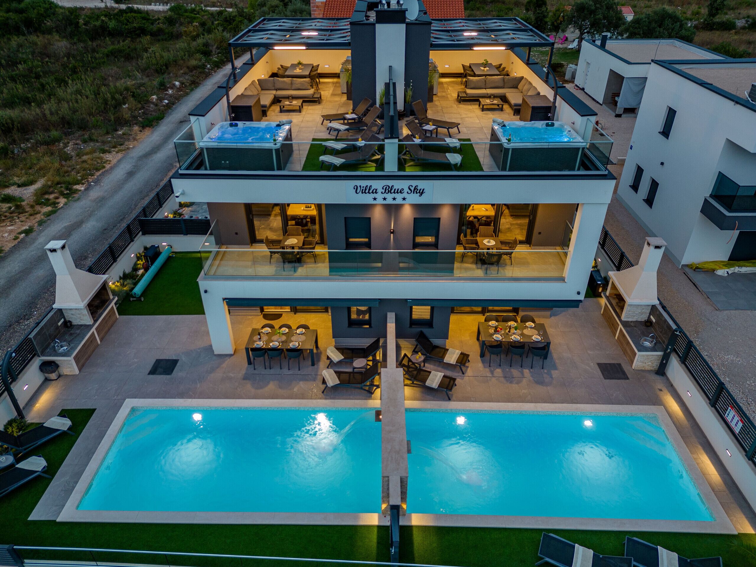 A modern hotel with a rooftop terrace, a swimming pool, and a dining area.