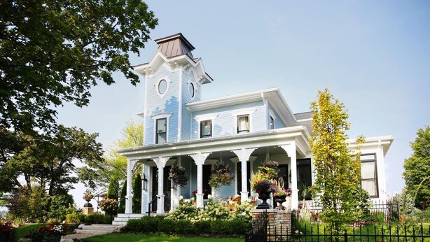 A large, two-story house with a prominent tower, a covered porch, and a well-maintained garden. - The Lilley Mansion Bed & Breakfast (Spring Lake)