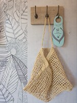 Una pared con una placa de madera y dos ganchos, uno con una etiqueta que dice 'si' y 'por favor, limpie mi habitación'.