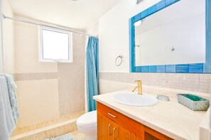 Ein Badezimmer mit Dusche, Toilette und Waschbecken.