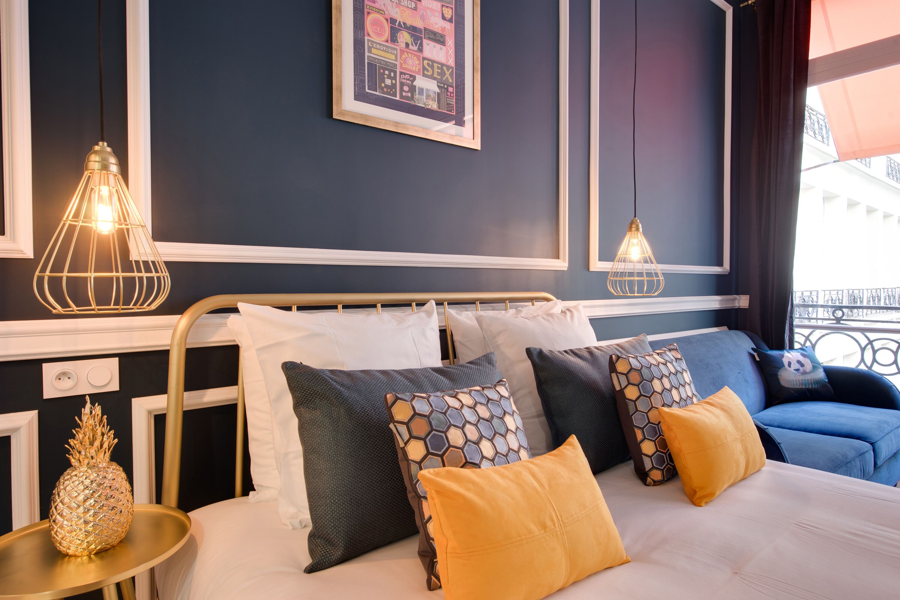 A hotel room with a bed, bedside tables, and a wall-mounted picture.
