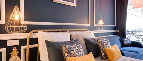 A hotel room with a bed, bedside tables, and a wall-mounted picture.