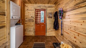 A cabin interior with a wooden interior, a door with a plaid curtain, a sign indicating a cabin, and a wall-mounted rack with items. -  Arrowhead Sanctuary!! Beautiful Cabin! Deck with Fire Pit & Incredible Views! (Cimarron)