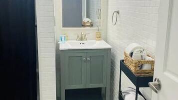 Tina con regadera, toallas, jabón, shampoo