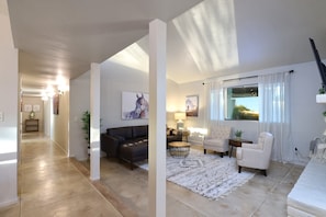 A spacious living area with a sofa, armchairs, a coffee table, and a rug. - Tierra Velo - HGTV Style in East Tucson (Tucson)