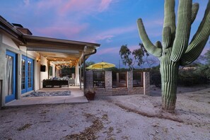 A house with a covered patio, a large cactus, and a desert landscape. - Tierra Velo - HGTV Style in East Tucson (Tucson)