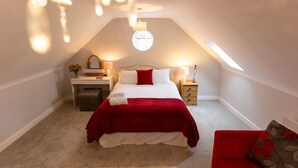 A bedroom with a bed, bedside tables, a nightstand, a mirror, a chandelier, and a red sofa. - Superb space in the idyllic village of Loppington - Pass the keys (Shrewsbury)