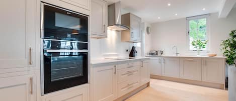 Mikrobølgeovn, ovn, oppvaskmaskin og høy barnestol