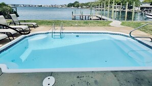 Une piscine avec vue sur l’eau et un quai.