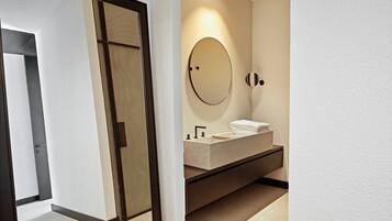 Un baño moderno con un espejo grande, un lavabo y un perchero para toallas.