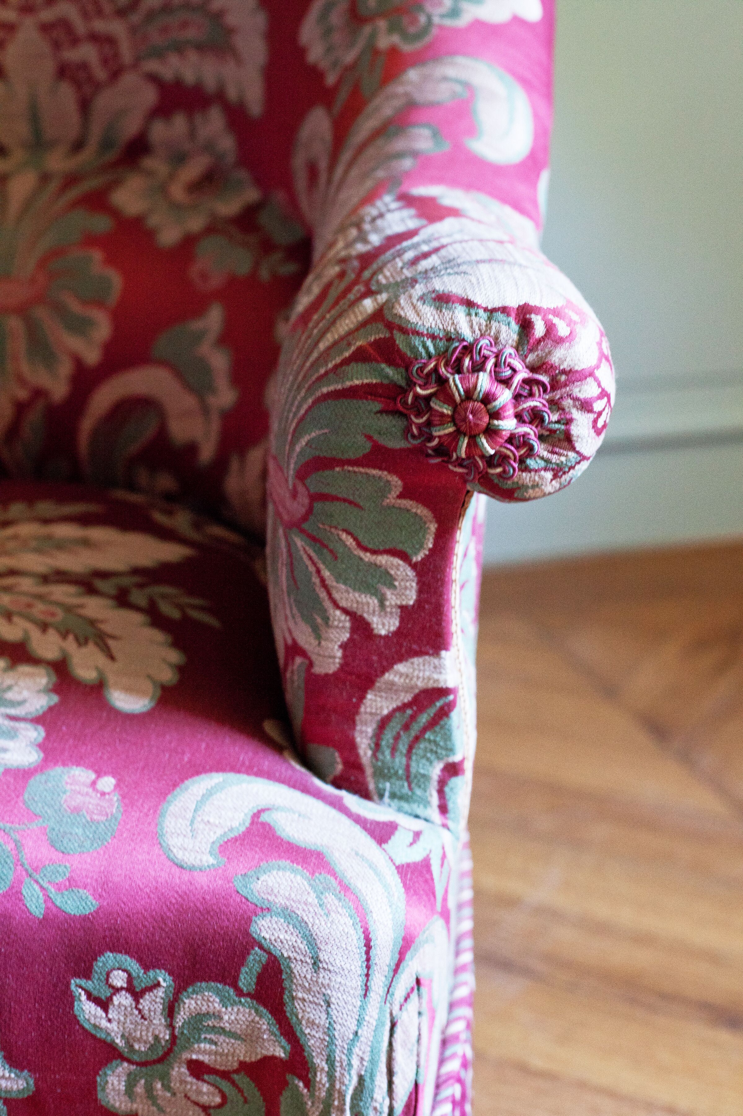 A close-up of a chair with a floral pattern upholstery.