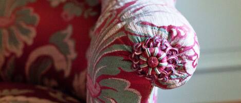 A close-up of a chair with a floral pattern upholstery.