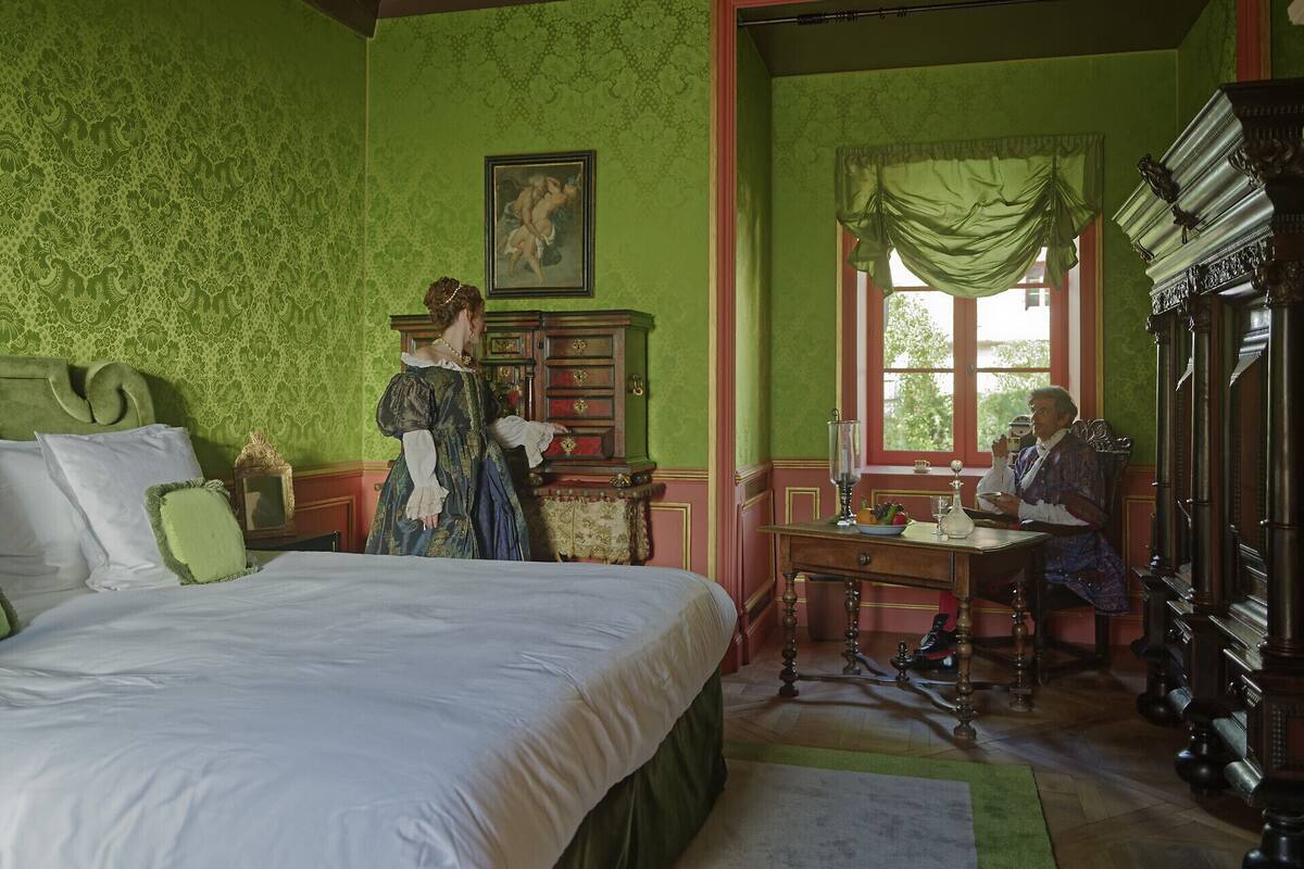 Una habitación con una cama grande, un armario de madera y una mesa con una silla.