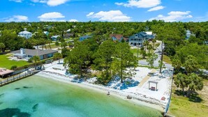 An aerial view of a coastal property with a beach, houses, and a pier. - Waterfront Sunsets~ Private Dock ~ Heated pool! (Panama City)