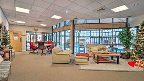 A spacious lobby with a large window, a Christmas tree, and a reception area with a desk and chairs. - Camelback House · Waterparks, Hiking, Wineries - Near Everything!!! (Tannersville)
