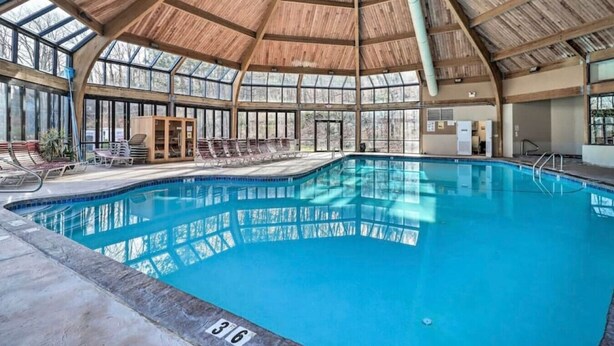 An indoor swimming pool with a wooden roof and large windows. - Camelback House · Waterparks, Hiking, Wineries - Near Everything!!! (Tannersville)