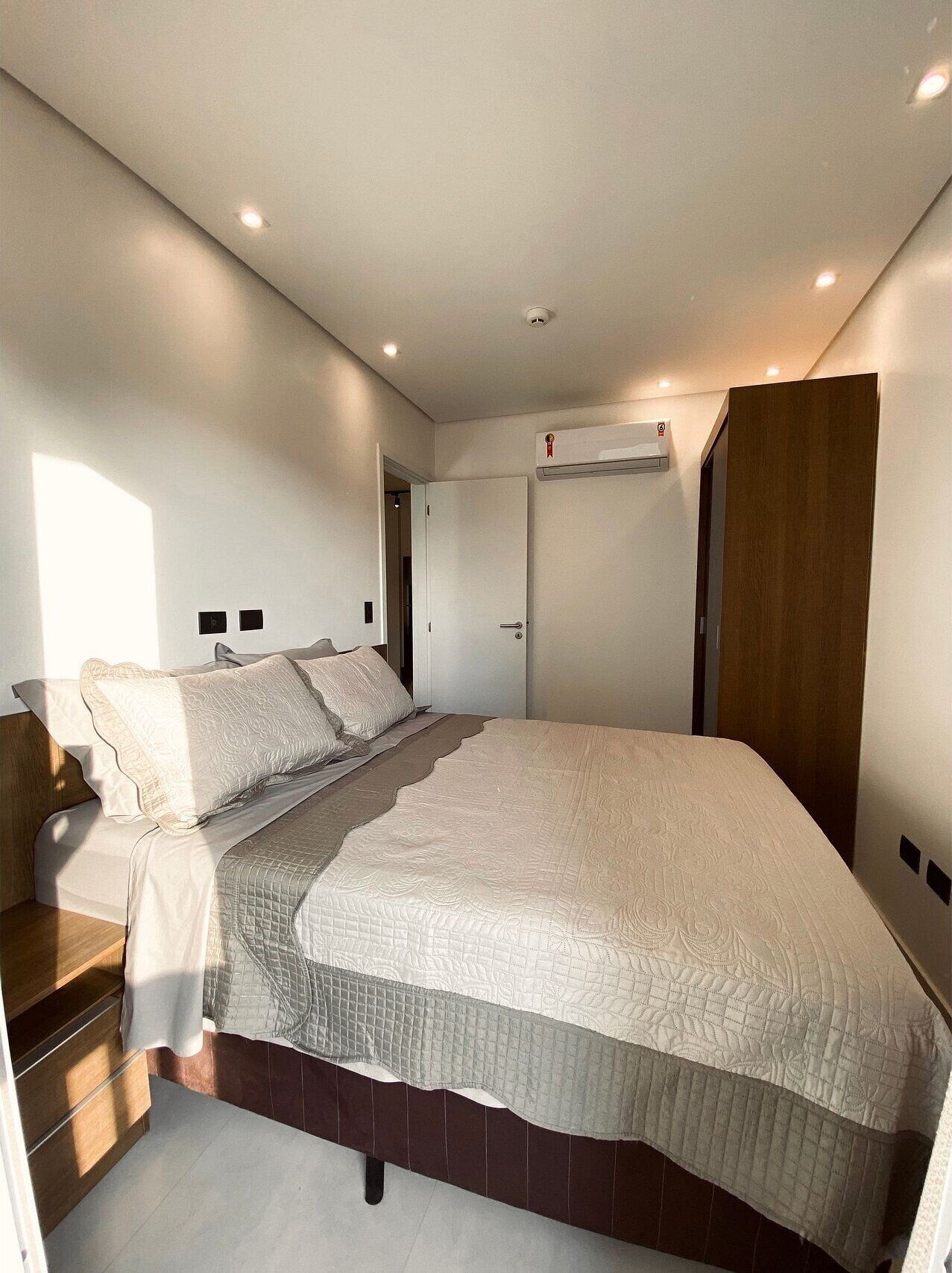 A bedroom with a bed, a wardrobe, and a door.