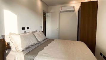 A bedroom with a bed, a wardrobe, and a door.