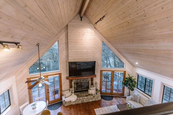 Cozy retreat with a fireplace, flat-screen TV, and forest views.