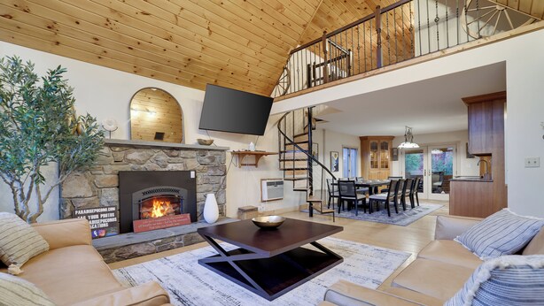 A spacious living area with a stone fireplace, a flat-screen TV, and a cozy seating arrangement. - Paradise Pocono - Ultimate Arcade, Salt Pool and Hot Tub - Sleeps 14 (Cresco)