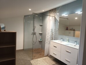 A modern bathroom with a glass-enclosed shower, a large mirror, and a vanity with a sink. - Between bocage sea and marais poitevin (Thiré)
