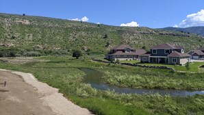 Un quartier résidentiel avec des maisons, une rivière et un paysage vallonné.