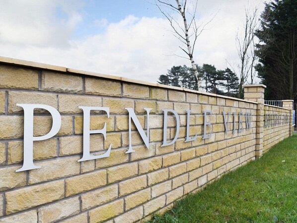 A stone wall with the words "PENDLE VIEW" in large, capital letters. - Luxury 2 bedroom, pet-friendly lodge on the side of a beautiful fishing lake. (Clitheroe)