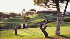 Un campo de golf con un club de campo al fondo.
